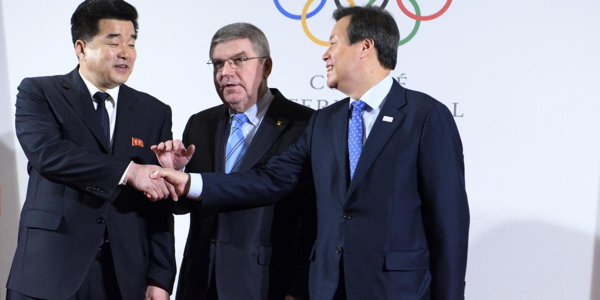 El presidente del Comité Olímpico Thomas Bach (C), estrechando las manods del Primer Ministro del Deporte de Corea del Norte, Kim Il Guk (Izq.) y el Primer Ministro del deportes de Corea del Sur, Jong-hwan, (Der.)