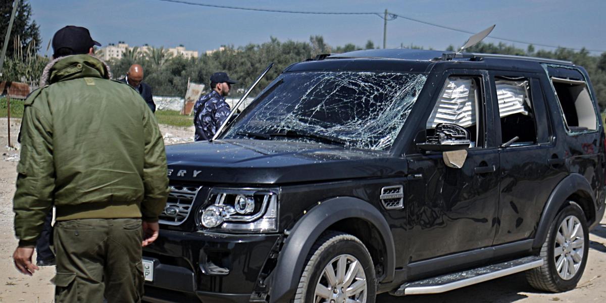 Agentes de seguridad inspeccionan uno de los vehículos del convoy del primer ministro de la ANP, Rami Hamdala, que fue atacado en Gaza.