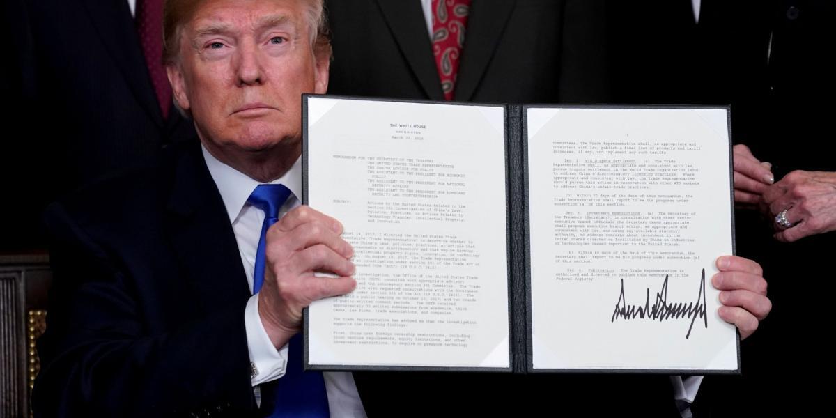 El presidente Trump muestra, en la Casa Blanca, su orden para endurecer aranceles a China, firmada este jueves.