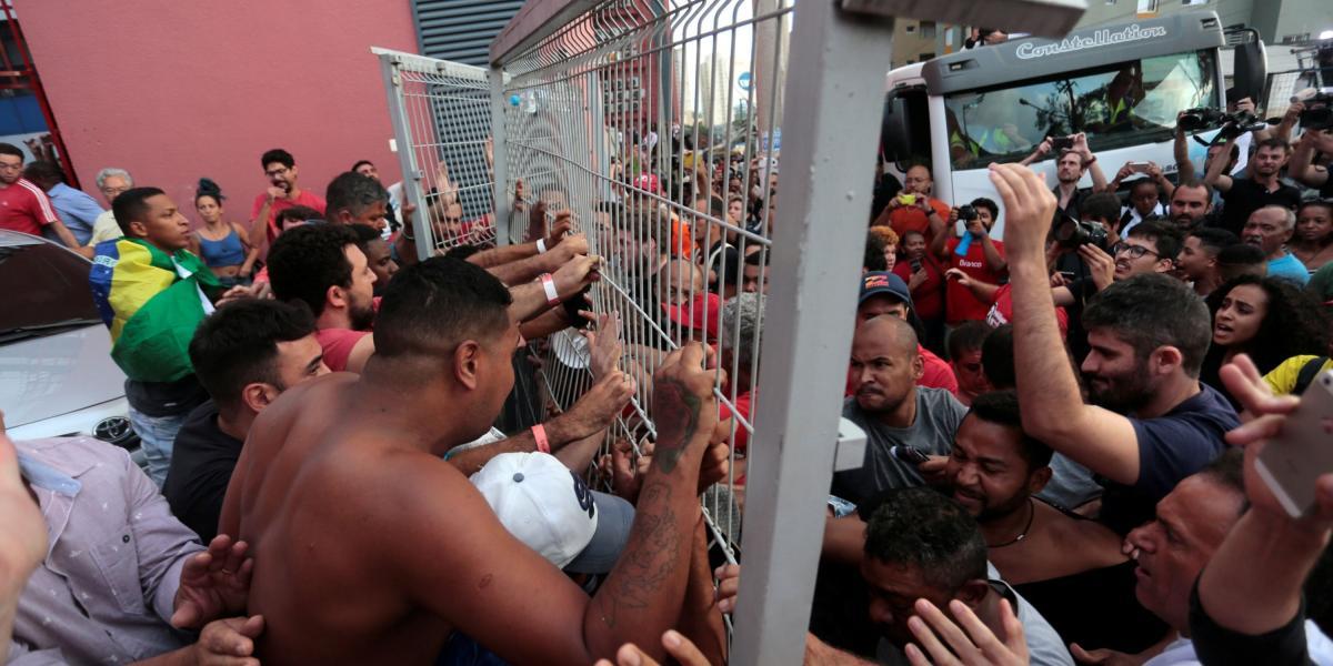 Simpatizantes de Lula da Silva bloquean la puerta mientras el expresidente brasileño intenta salir.
