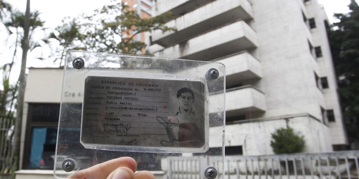 Un guía turístico muestra la supuesta cédula de Pablo Escobar a los extranjeros que están en un tour en el edificio Mónaco.