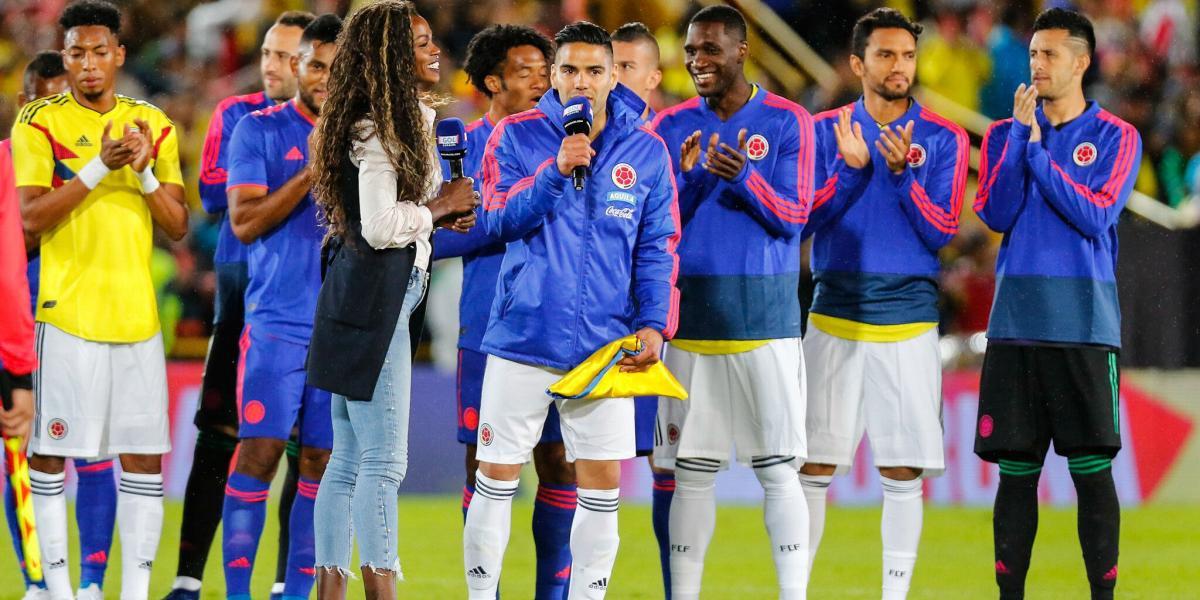 Falcao García recibe de manos de Caterine Ibargüen la bandera de Colombia.