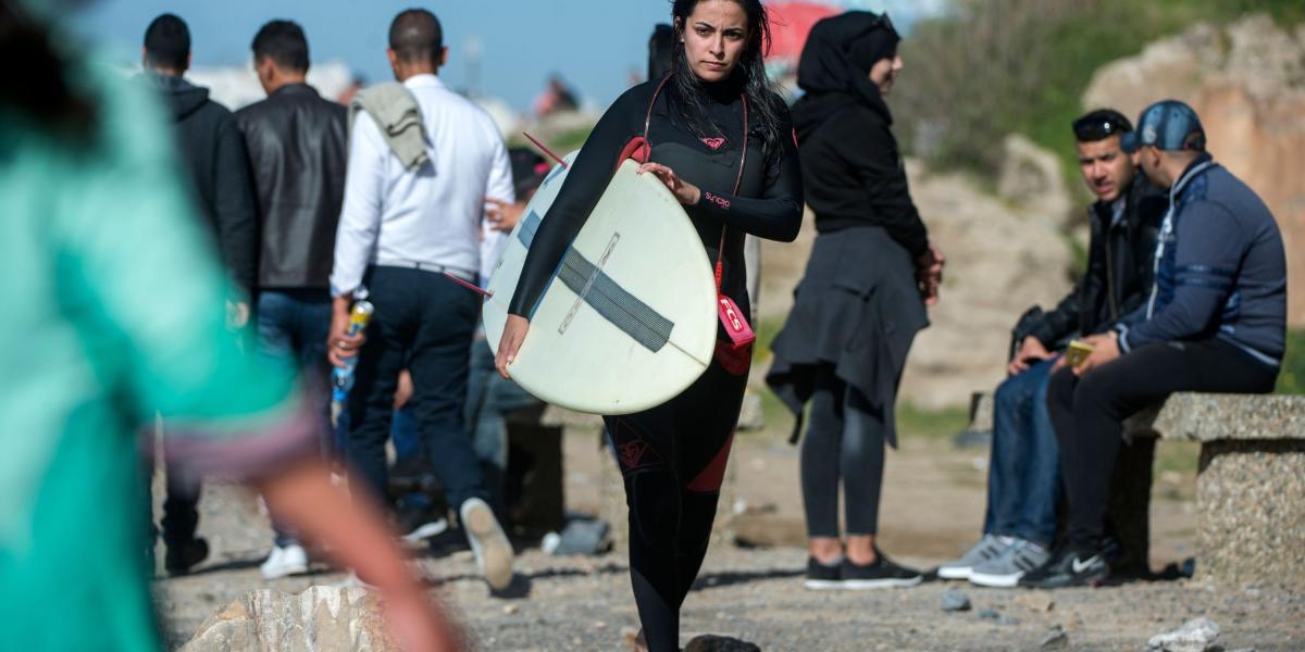 Meriem, una surfista e ingeniera de 29 años, camina sola por las playas de Rabat después de una sesión.