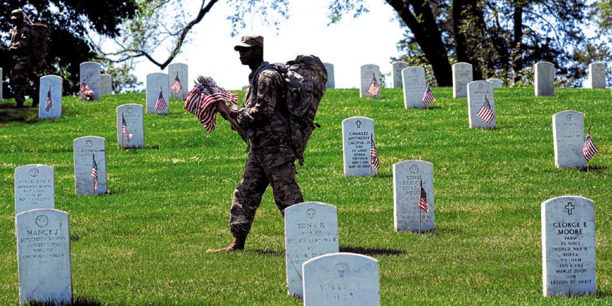 Un soldado pone banderas de Estados Unidos sobre las tumbas de los caídos durante la celebración del Memorial Day, en el famoso cementerio de Arlington.