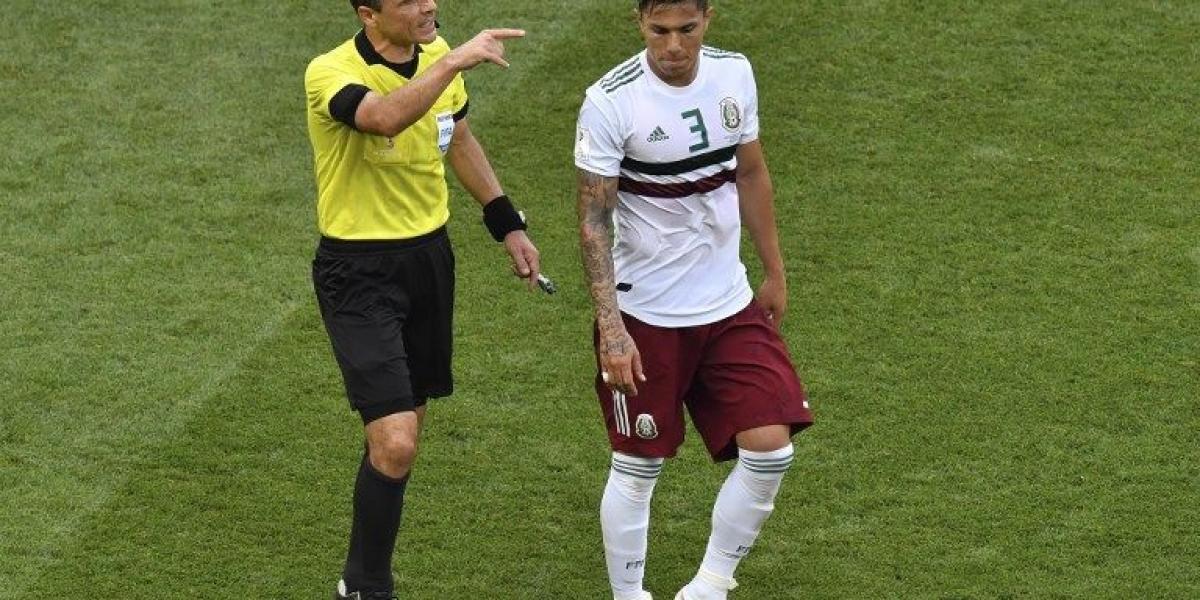 El árbitro Milorad Mazic durante el partido de México vs. Corea, con el defensor de Carlos Salcedo.