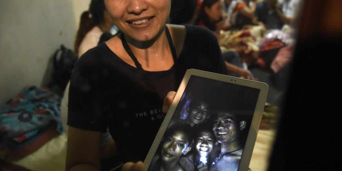 Una de las familiares de los menores sostiene una tableta en la que muestra la foto de los niños, que estuvieron desaparecidos por nueve días.