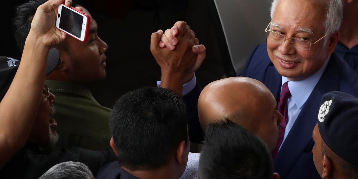 El ex primer ministro malasio Najib Razak (d.) saludó a sus simpatizantes a su salida del Tribunal Supremo en Kuala Lumpur (Malasia) después de ser acusado en cargos con relación a la presunta malversación millonaria del fondo estatal.