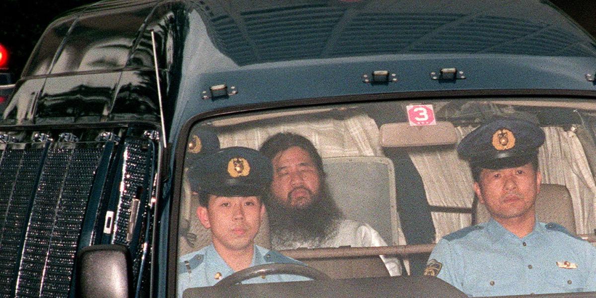 Foto de archivo del 16 de junio de 1995, que muestra al fundador del culto Aum Shinrikyo, Shoko Asahara (c), con nombre de nacimiento Chizuo Matsumoto, quien es escoltado por la policía.