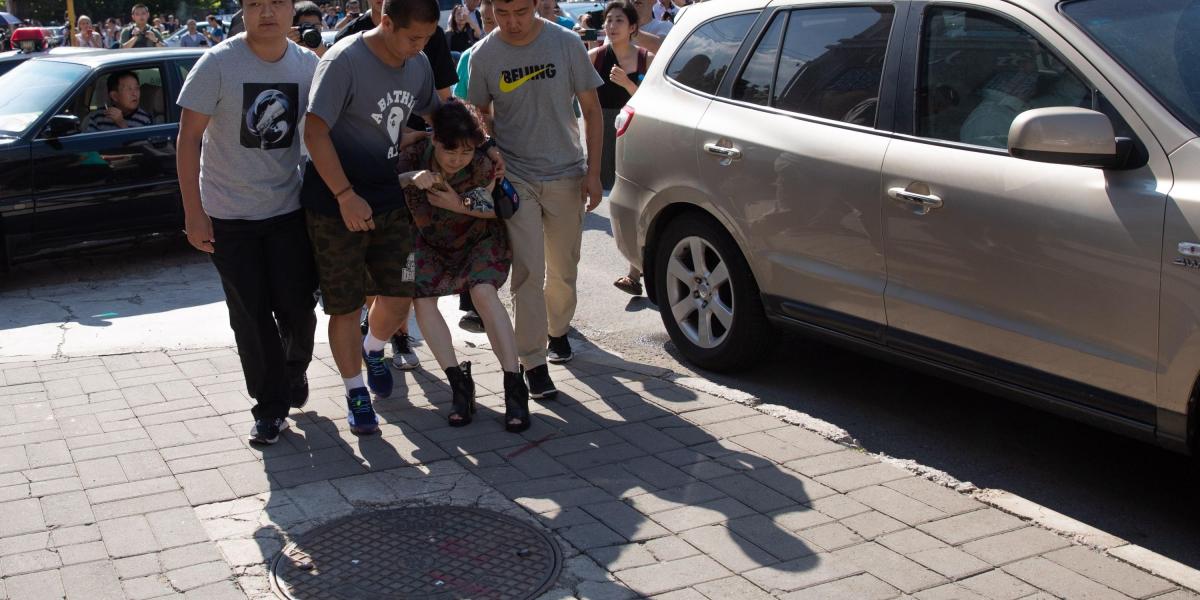 Policías de paisano arrestan a una mujer cerca de la Embajada de Estados Unidos en Pekín (China) este jueves.Un pequeño artefacto estalló en las afueras de la Embajada de Estados Unidos en Pekín y causó heridas al autor del incidente, informaron testigos presenciales y un portavoz de la propia legación.