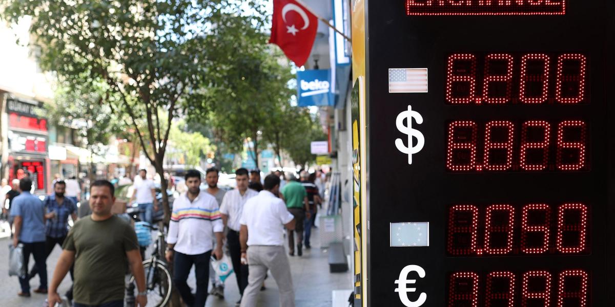 Ciudadanos pasean junto a un centro de cambio de divisas en Estambul, Turquía. El Banco Central de Turquía (TCMB) anunció la inyección de 6.000 millones de dólares en el sistema financiero del país para garantizar la liquidez de los bancos y detener el desplome de la lira turca.