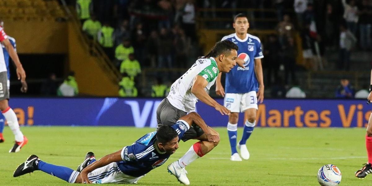 Christian Marrugo (izq.) cae en la lucha por la pelota con Diego Arias. Millonarios y Once Caldas empataron 2-2 en Bogotá.