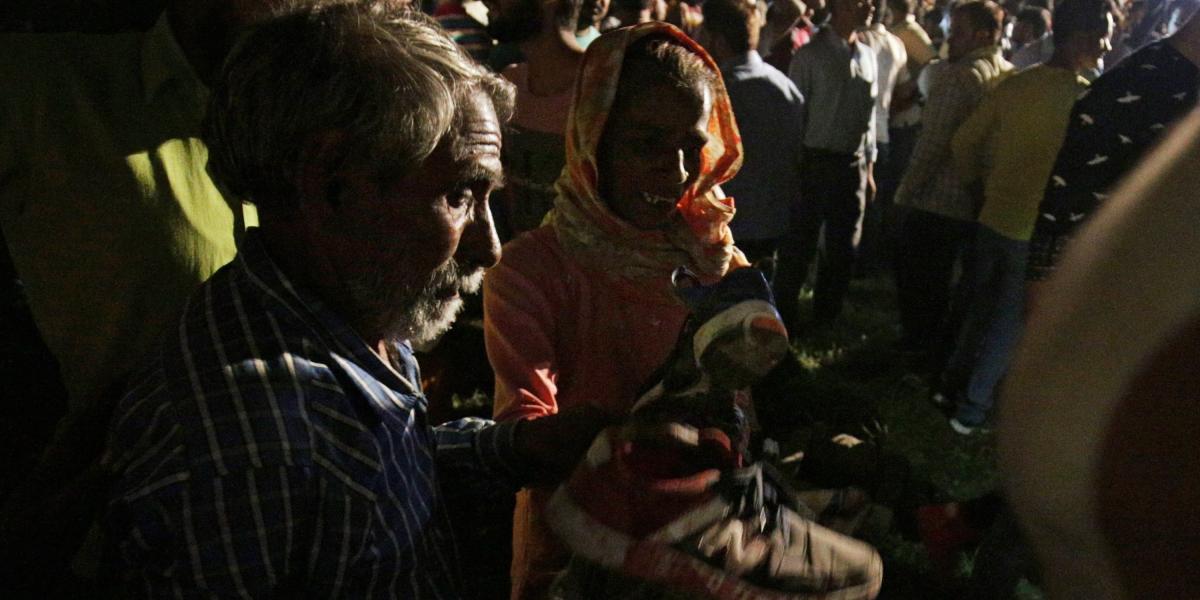 Una mujer recoge el zapato de una víctima de un  accidente de tren mientras busca a su hijo en Amritsar, India.