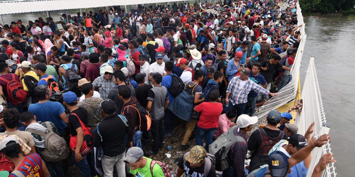 Migrantes hondureños esperan la oportunidad de cruzar la frontera entre Guatemala y México en su camino hacia Estados Unidos.