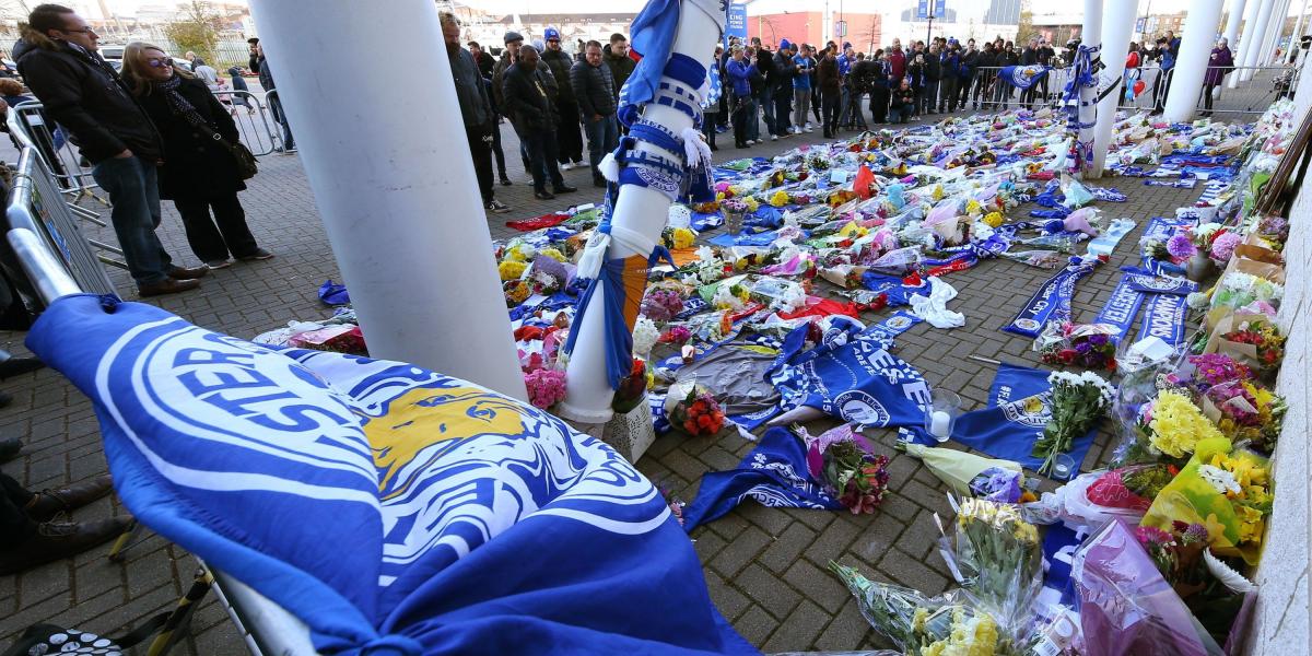 Decenas de personas se acercaron este domingo al estadio del 
Leicester City para depositar flores, velas y mensajes de ánimo tras el accidente del helicóptero.