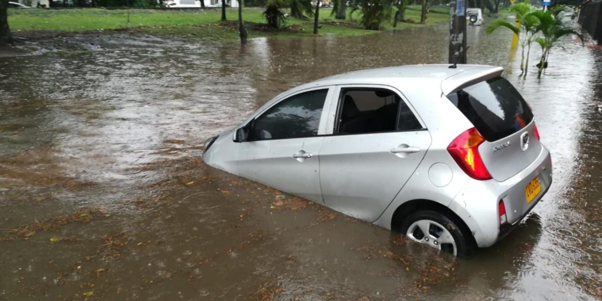 Un carro 'clavó' en un tramo inundado de la avenida 4 con calle 52 Norte del barrio La Flora de Cali.