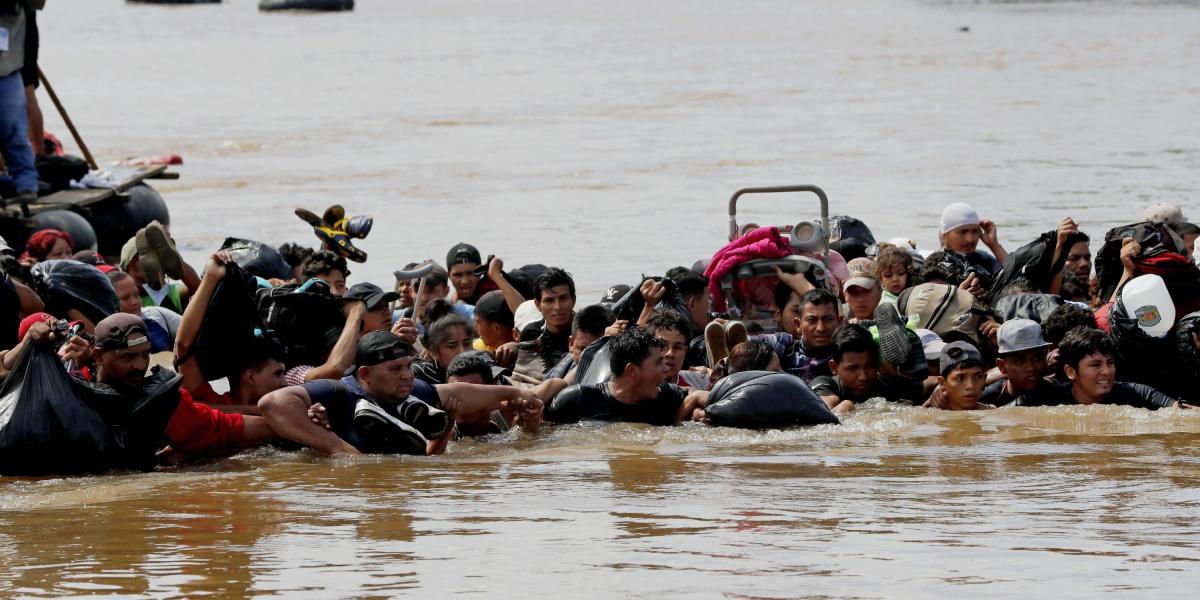 Integrantes de la segunda caravana de migrantes, en su mayoría hondureños, cruzan el río Suchiate (el cual separa Guatemala de México), en un nuevo intento por continuar su travesía hacia Estados Unidos. Esta segunda caravana salió el pasado 13 de octubre de San Pedro Sula (Honduras) y está formada por 7.000 personas.