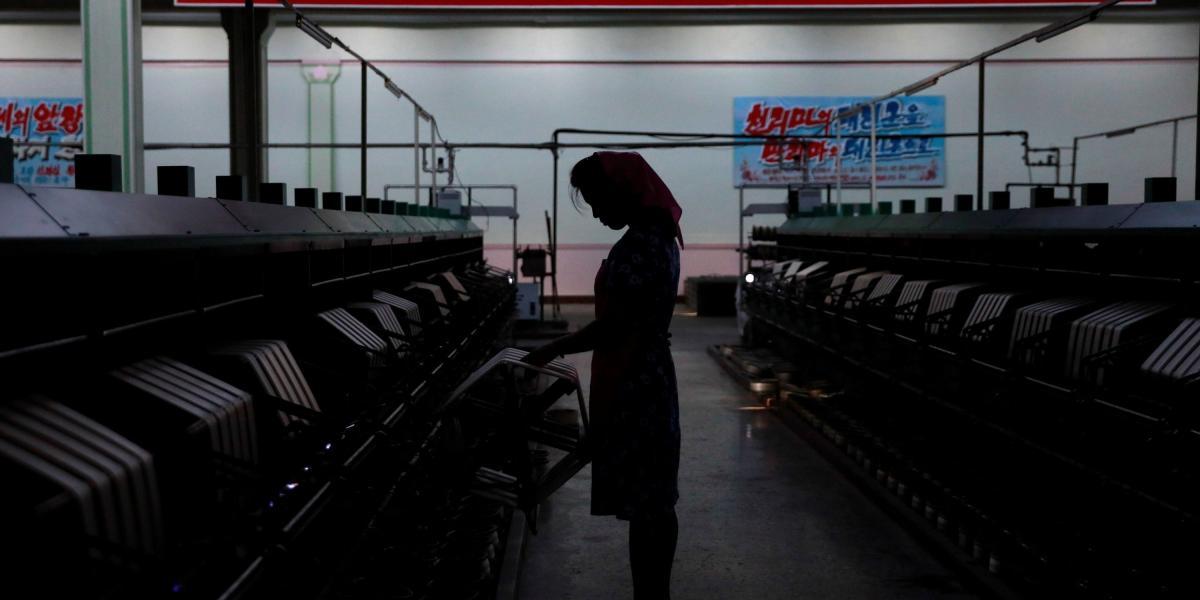 Fotografía de archivo que muestra la silueta de una empleada norcoreana en una fábrica de seda en Pyongyang, Corea del Norte.