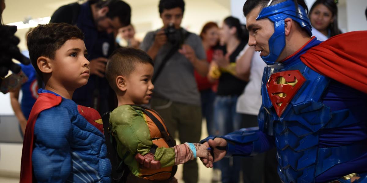 Supermán saluda a otros superhéroes en uno de los hospitales que visitó la Liga de la Alegría.