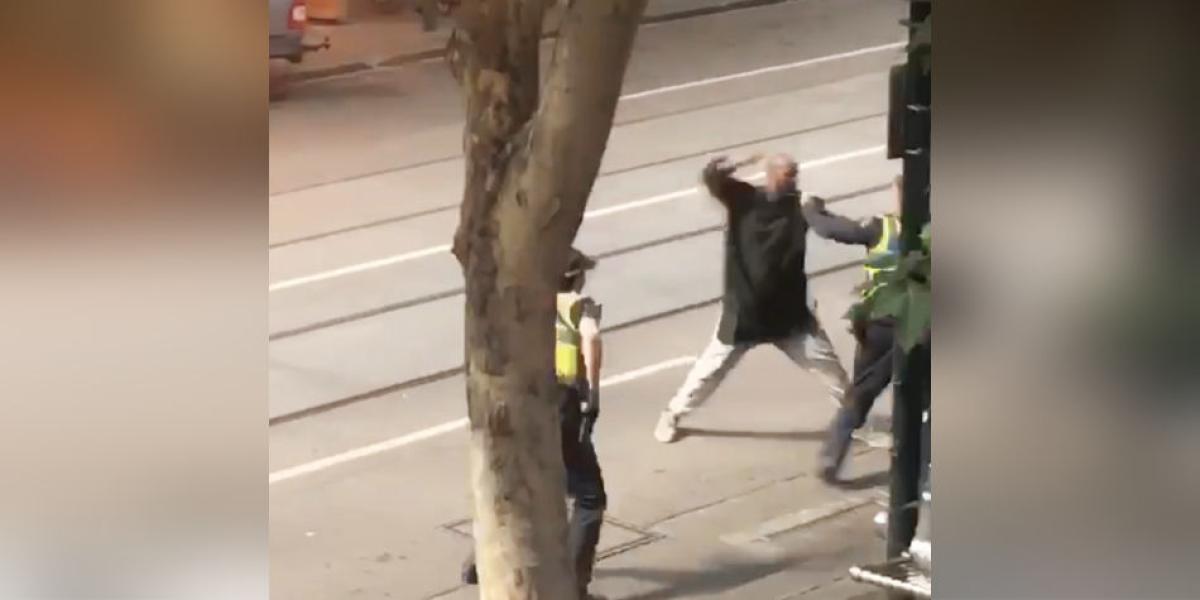 Captura de vídeo que muestra a un hombre armado con un cuchillo mientras se enfrenta a los agentes después de atacar a varias personas en la calle Bourke de Melbourne.