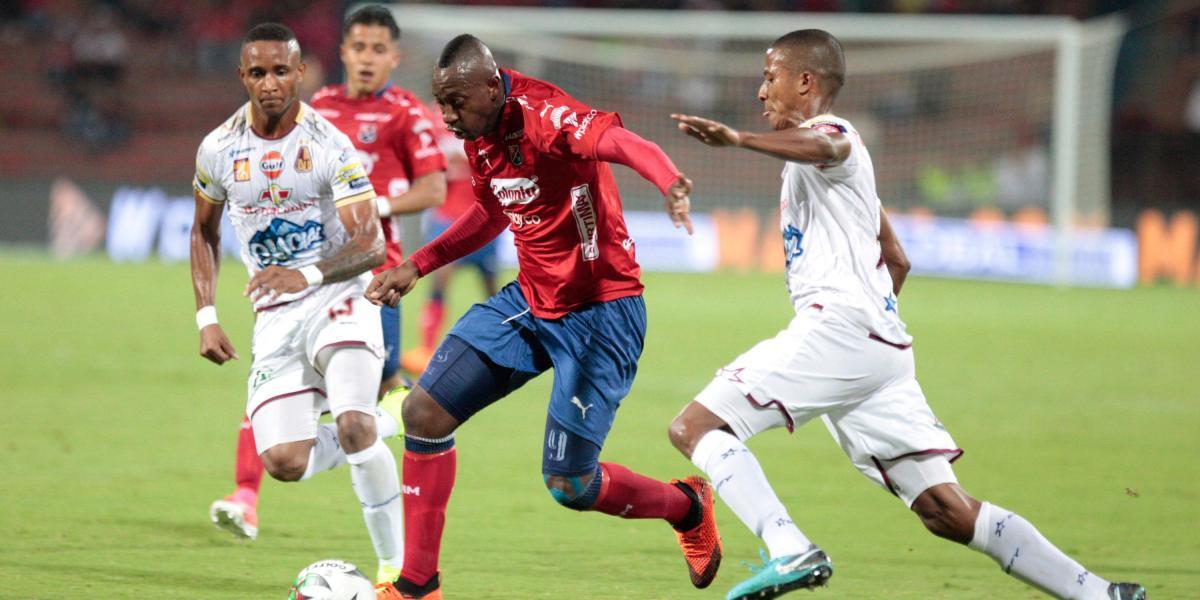 Juan Fernando Caicedo (centro) se abre paso entre dos rivales en el 2-2 entre Medellín y Tolima.