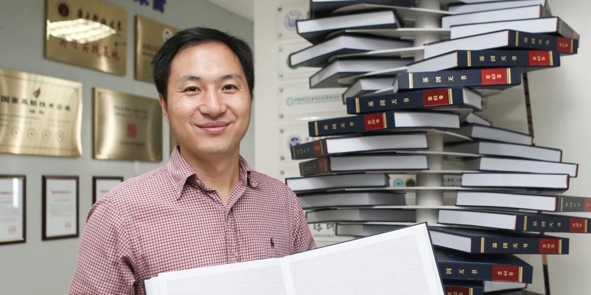 El científico chino He Jiankui posa con su libro ‘El genoma humano’ (2016).