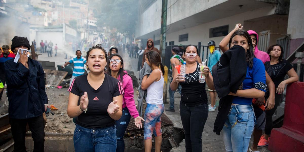 Un grupo de personas se manifiestan en una calle en las inmediaciones de un comando de la Guardia Nacional Bolivariana este lunes, en Carcas (Venezuela). Un grupo de militares que se había rebelado contra el Gobierno de Nicolás Maduro fue "rendido y capturado".