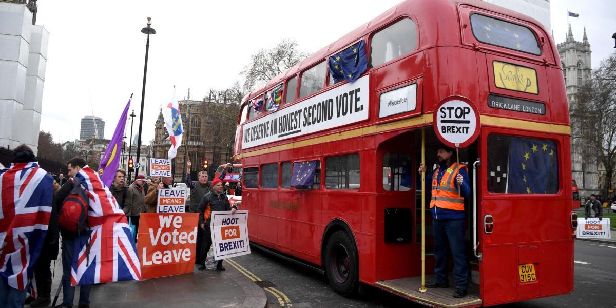 Manifestantes a favor del 'brexit' protestan frente a un autobús en el que pueden leerse consignas contrarias a la salida del país de la Unión Europea (UE), este martes en el exterior del Parlamento de Londres (Reino Unido).