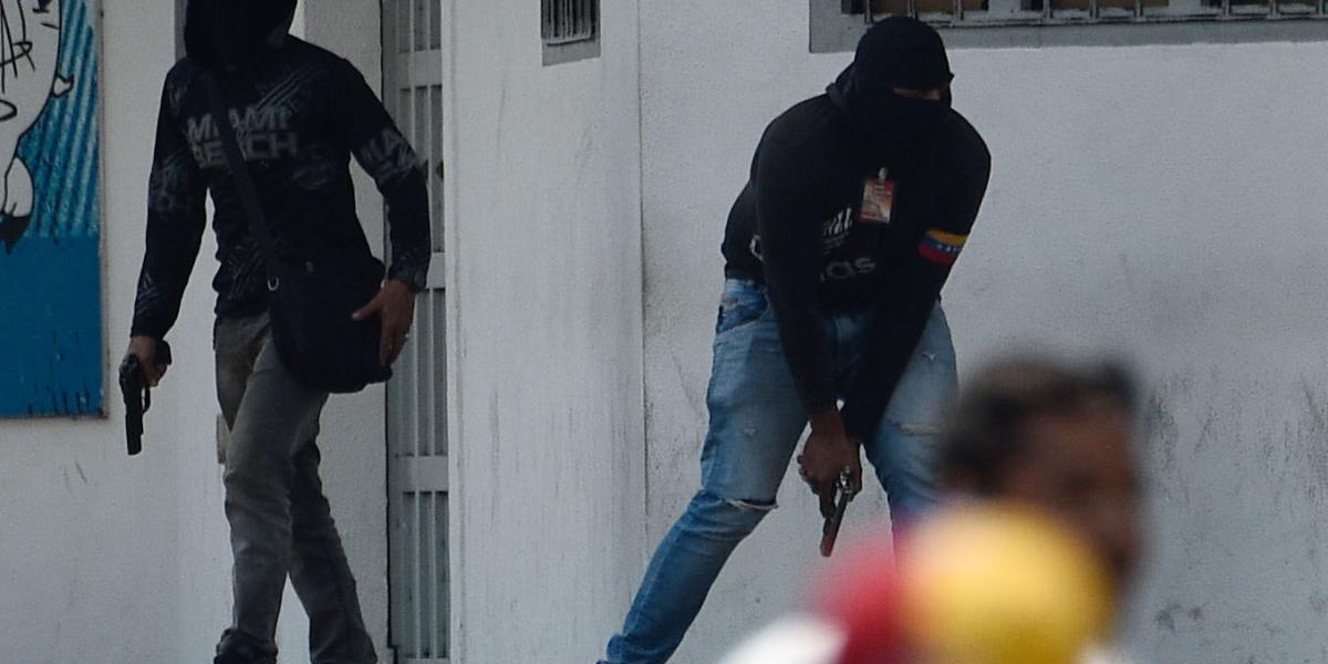 Un miembro de los colectivos chavistas dispara su arma para disuadir a los manifestantes en San Antonio, estado Táchira.