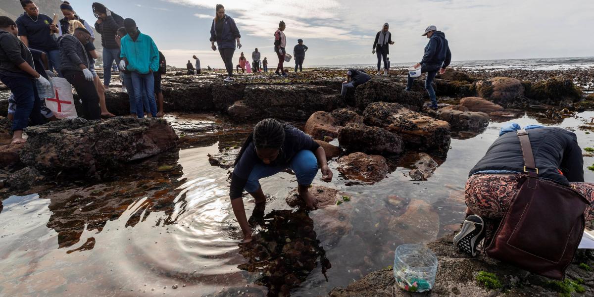 En mayo de este año, los estudiantes sudafricanos recogen desechos plásticos y escombros durante una limpieza en la playa de la zona intermareal de la piscina de marea Dalebrook en Kalk Bay, Ciudad del Cabo, Sudáfrica.