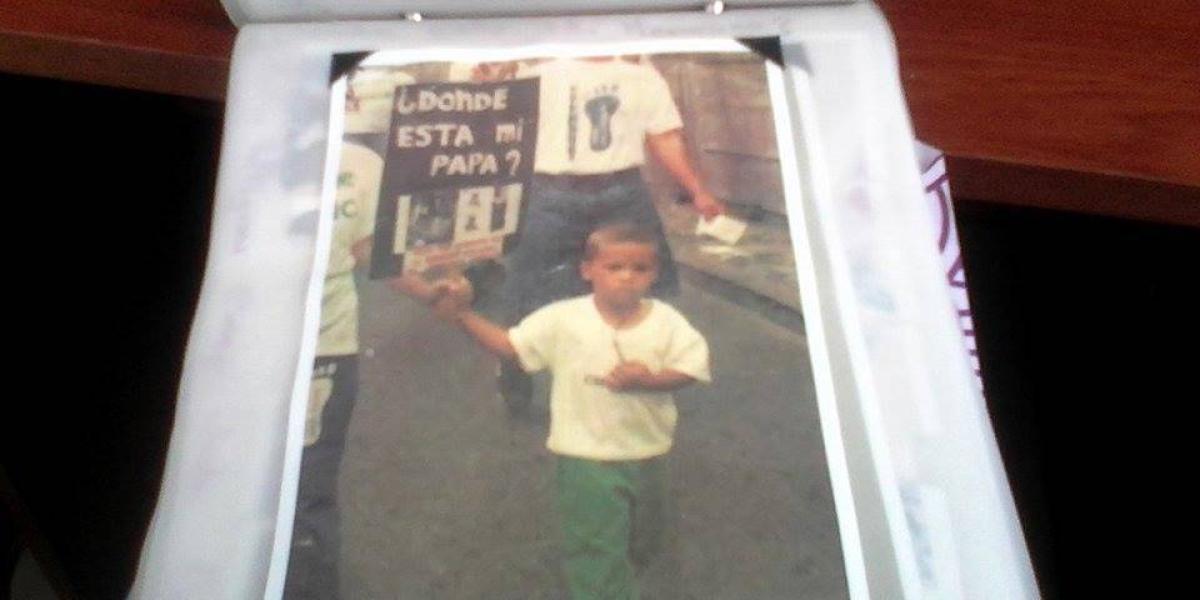 Imagen de Juan Fernando Quintero, de niño, con un cartel que dice '¿Dónde está mi papá?