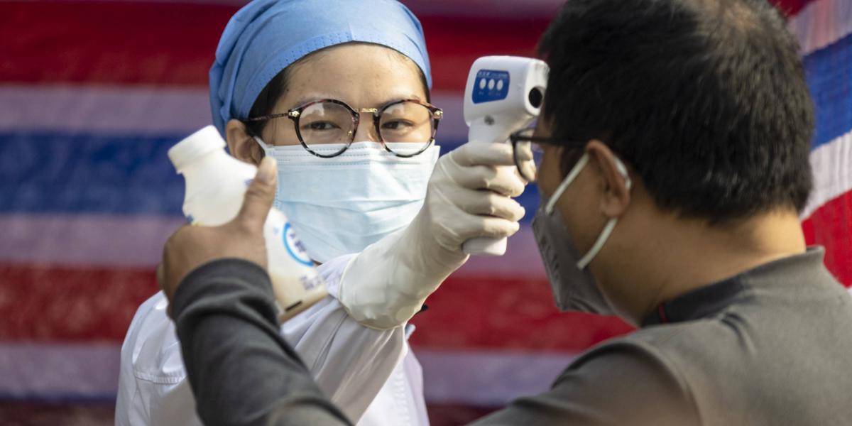 Personal médico toma la temperatura de ciudadanos de Guangzhou.