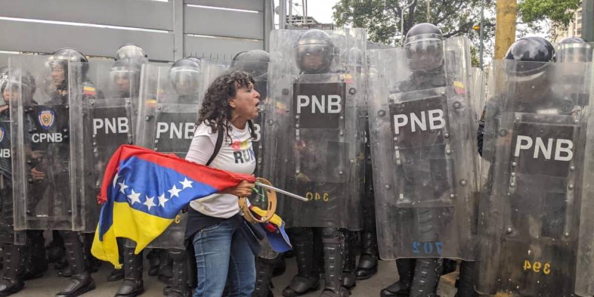 Una manifestante increpa a los mimebros de la Policía Bolivariana en Venezuela.