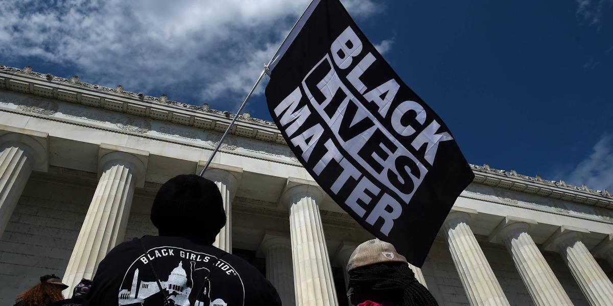 Un manifestante sostiene una bandera de "Black Lives Matter" durante la marcha en Washington.
