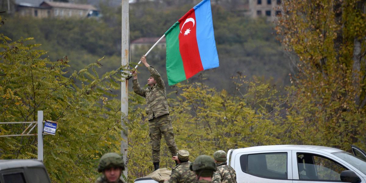 Un convoy militar coloca la bandera de Azerbaiyán en el centro desierto de la ciudad de Lachín.