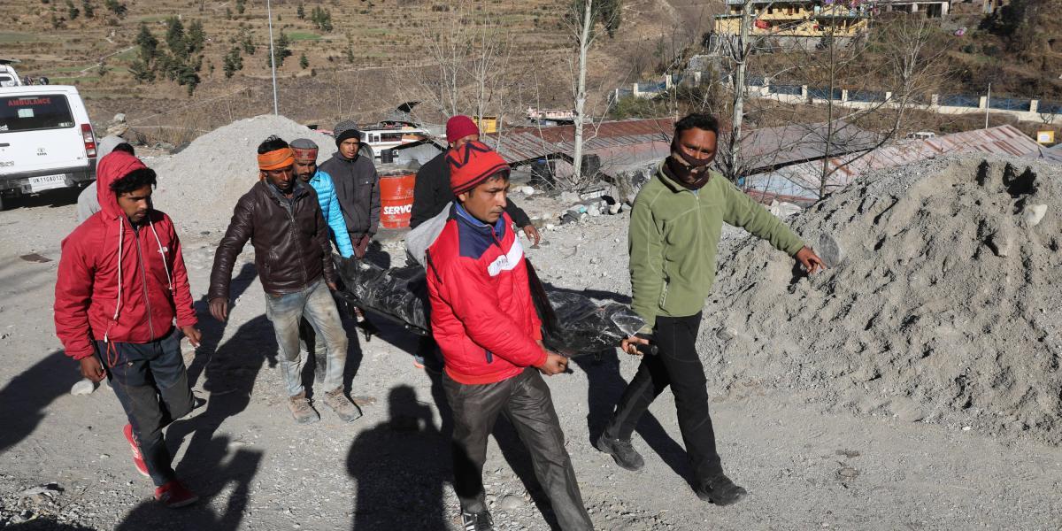 Hombres llevan un cuerpo recuperado cerca del dañado proyecto hidroeléctrico Dhauliganga en la aldea de Reni en el distrito de Chamoli en India.