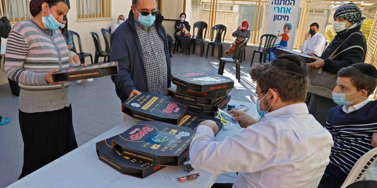 En algunos centros de vacunación en Tel Avid, las personas reciben pizzas después de recibir dosis de la vacuna contra el coronavirus de Pfizer-BioNtech.