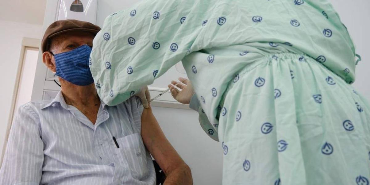 Adulto mayor recibe dosis de vacuna en la clínica Versalles de Cali.