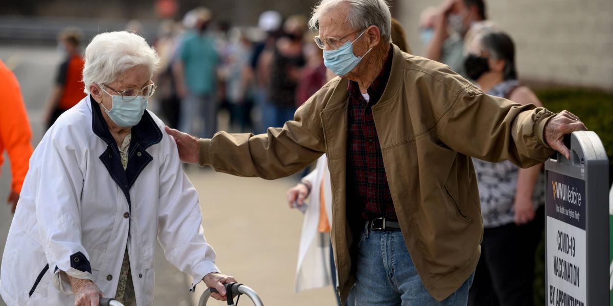 Residents wear protective masks while waiting outside of a West Virginia United Health System Covid-19 vaccine clinic in Morgantown, West Virginia, U.S., on Thursday, March 11, 2021.
