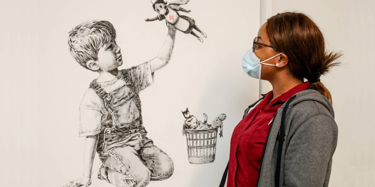 Una persona del Hospital Universitario Southampton observa la obra 'Game Changer', del artista Bansky.