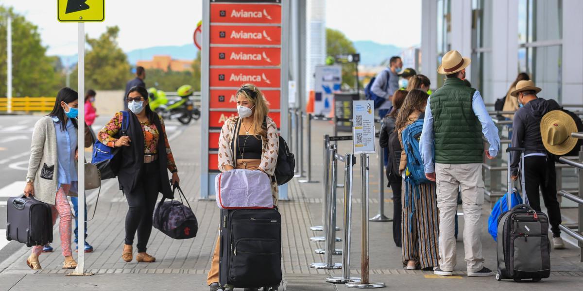 Viajeros llegan a la terminal aérea de Bogotá durante el plan éxodo por la temporada de semana santa en Colombia.