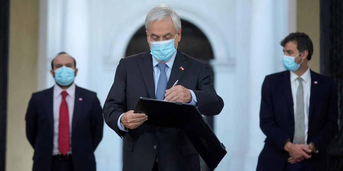 El presidente de Chile, Sebastián PIñera, mientras firma la reforma constitucional que aplaza las próximas elecciones.