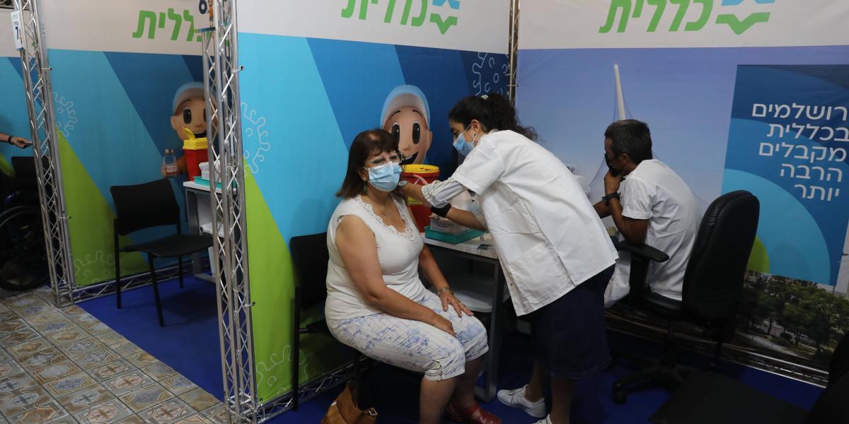 Un mujer Israelí recibe tercera dosis de vacuna contra el covid-19 en Jerusalén