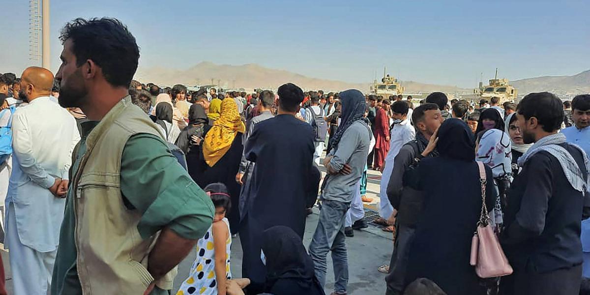 Cientos de afganos se agolpan en la pista del aeropuerto de Kabul el 16 de agosto de 2021 para huir del país, tras la toma de la ciudad por parte de los talibanes.