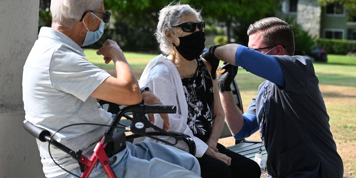 Dos jubilados latinos, ella de 81 y el de 80, reciben su tercera dosis de Pfizer en Pasadena, California.