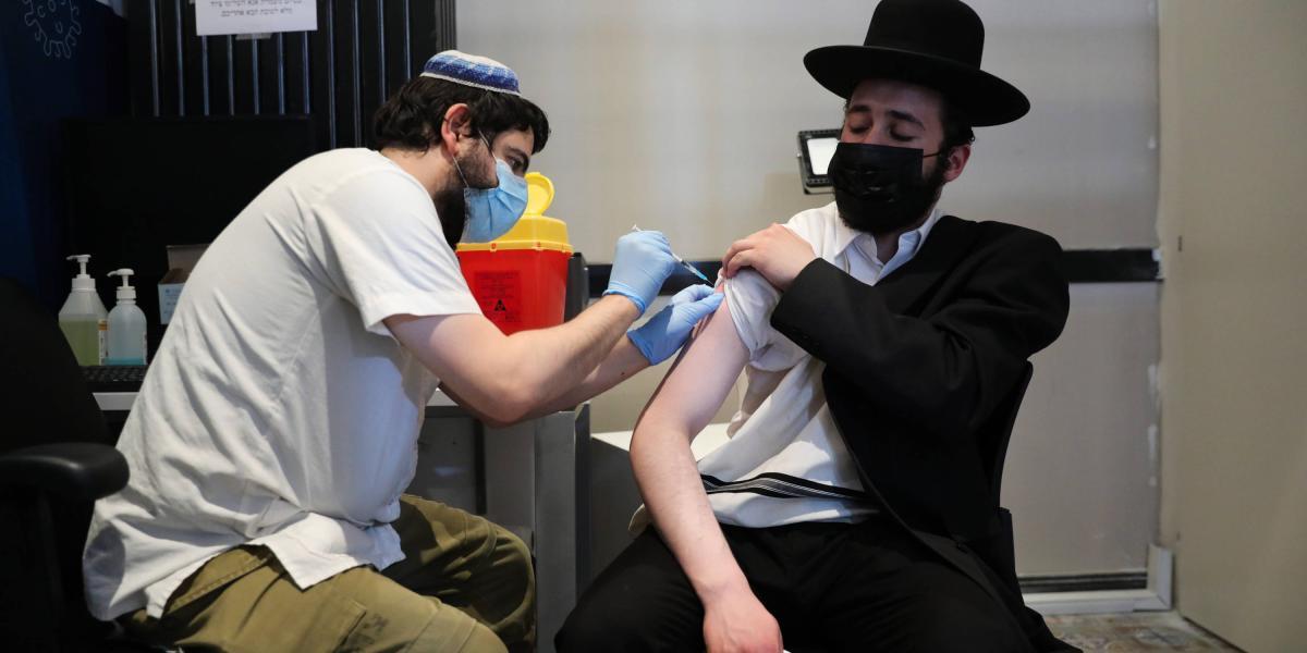 Una enfermera inyecta a un hombre ultraortodoxo una tercera inyección de la vacuna COVID-19 en Jerusalén, Israel, 30 de agosto de 2021.