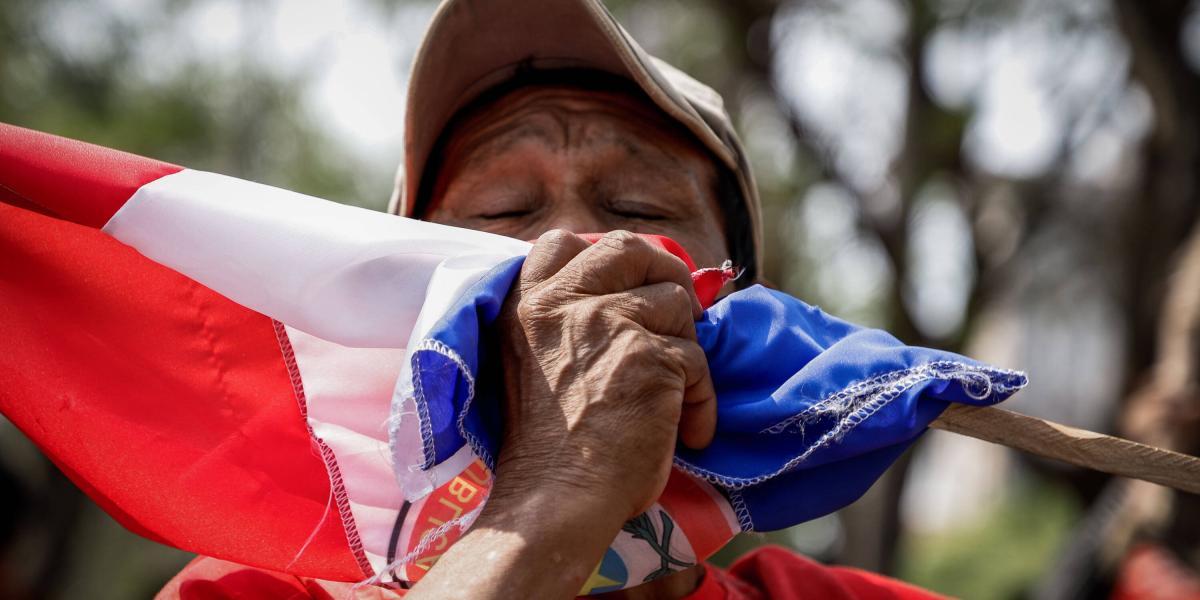 Un indígena besa hoy la bandera paraguaya mientras protesta frente al Congreso Nacional en Asunción.