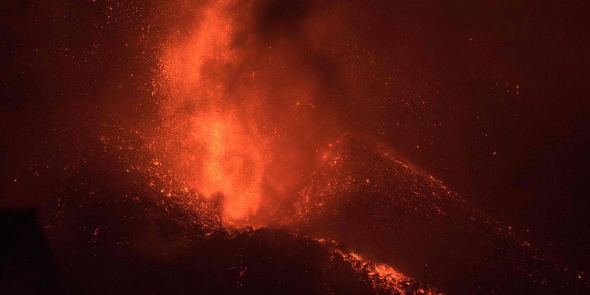 El volcán Cumbre Vieja, fotografiado desde El Paso, arroja lava, ceniza y humo, en la isla canaria de La Palma en la noche del 4 de octubre de 2021. Un nuevo flujo de lava altamente líquida emergió del volcán en erupción en las Islas Canarias de España en octubre 1, dijeron las autoridades, mientras una enorme plataforma de magma continúa construyéndose en el océano Atlántico.