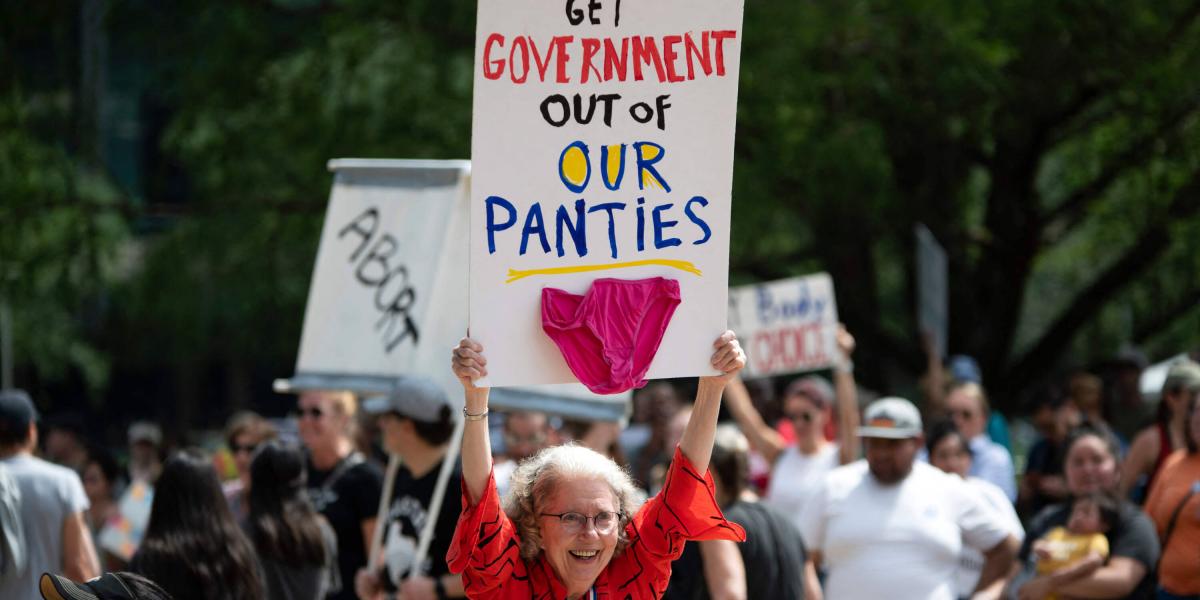 Una señora sostiene un cartel que dice: "Mantengan lejos al gobierno de nuestros calzones".