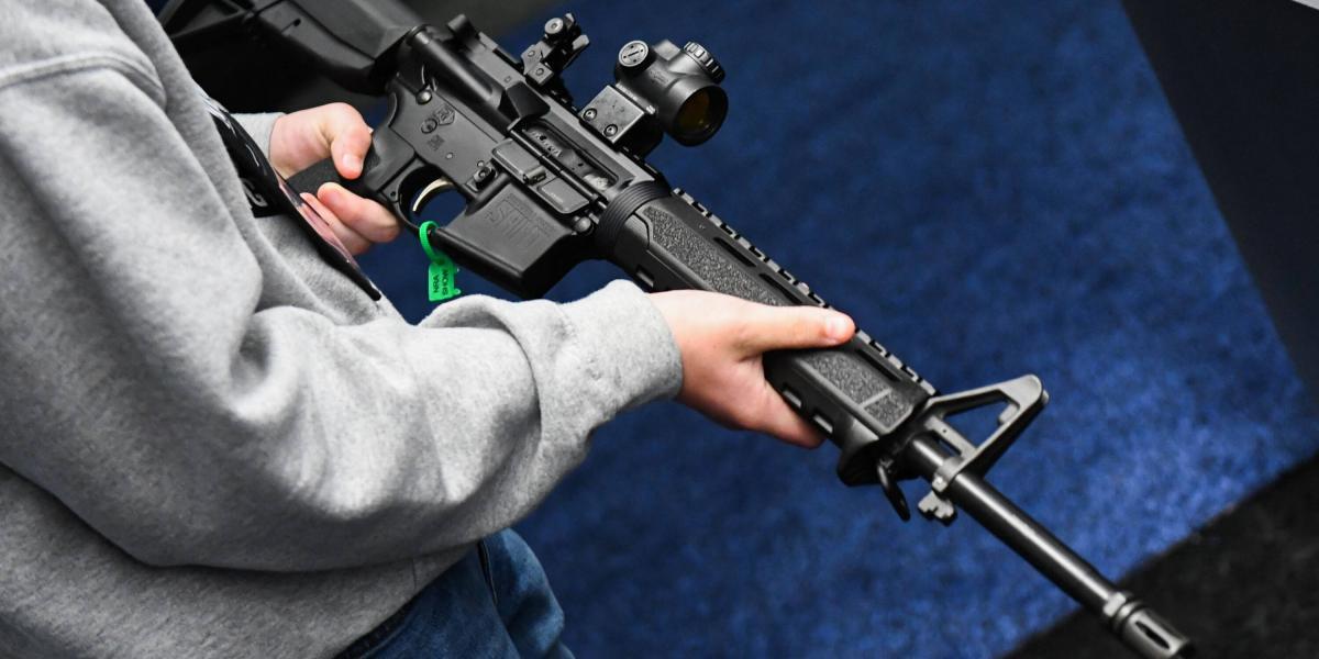 Un asistente sostiene en sus manos un rifle AR-15 presentado durante un encuentro de la Asociación Nacional del Rifle (Imagen de referencia).