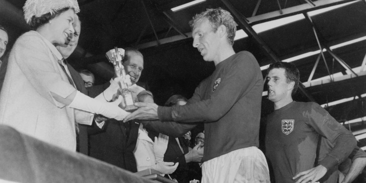 Bobby Moore (der.) recibe de la reina Isabel II la copa Jules Rimet, en 1966.